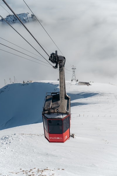 白天雪地上的红色缆车
